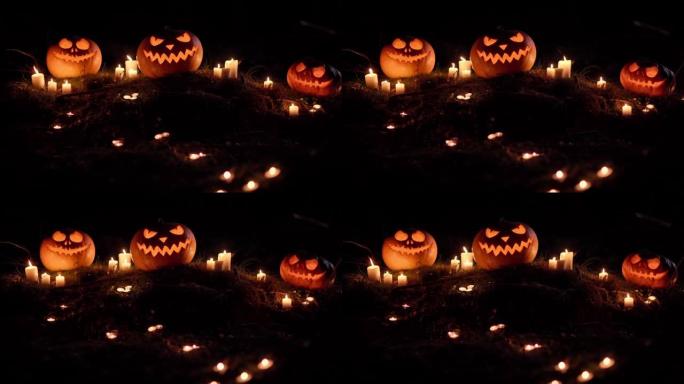 三个可怕的发光南瓜和闪电中燃烧的蜡烛的特写镜头。晚上后院的传统节日符号。令人毛骨悚然的神秘万圣节背景