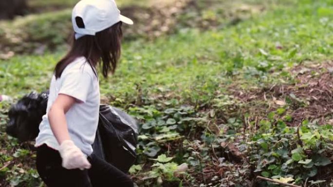 背面观看视频，一个志愿女孩拿着大黑色的袋子，垃圾不能上去，男人帮助她伸出一只手。