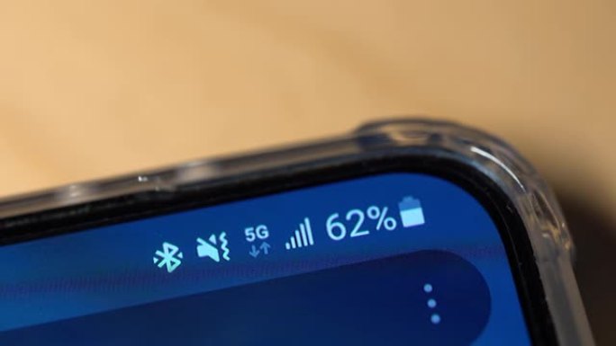 智能手机屏幕上的蓝牙图标和真实的5g信号。特写视图