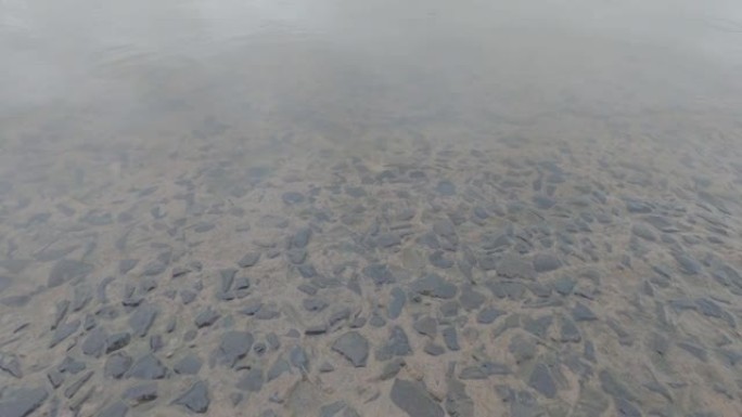 河水流淌在河岸上的混凝土石岩上。