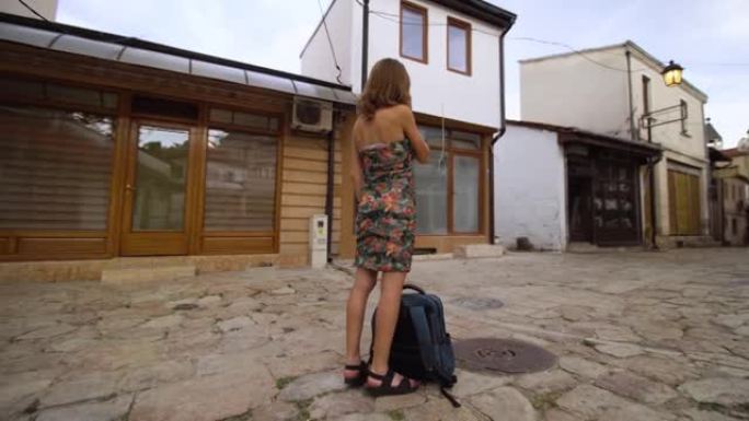 在马其顿北部斯科普里的老集市上，背着背包的女孩在打电话