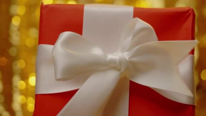 黄色bokeh背景的红色礼品盒，圣诞节和假期概念。