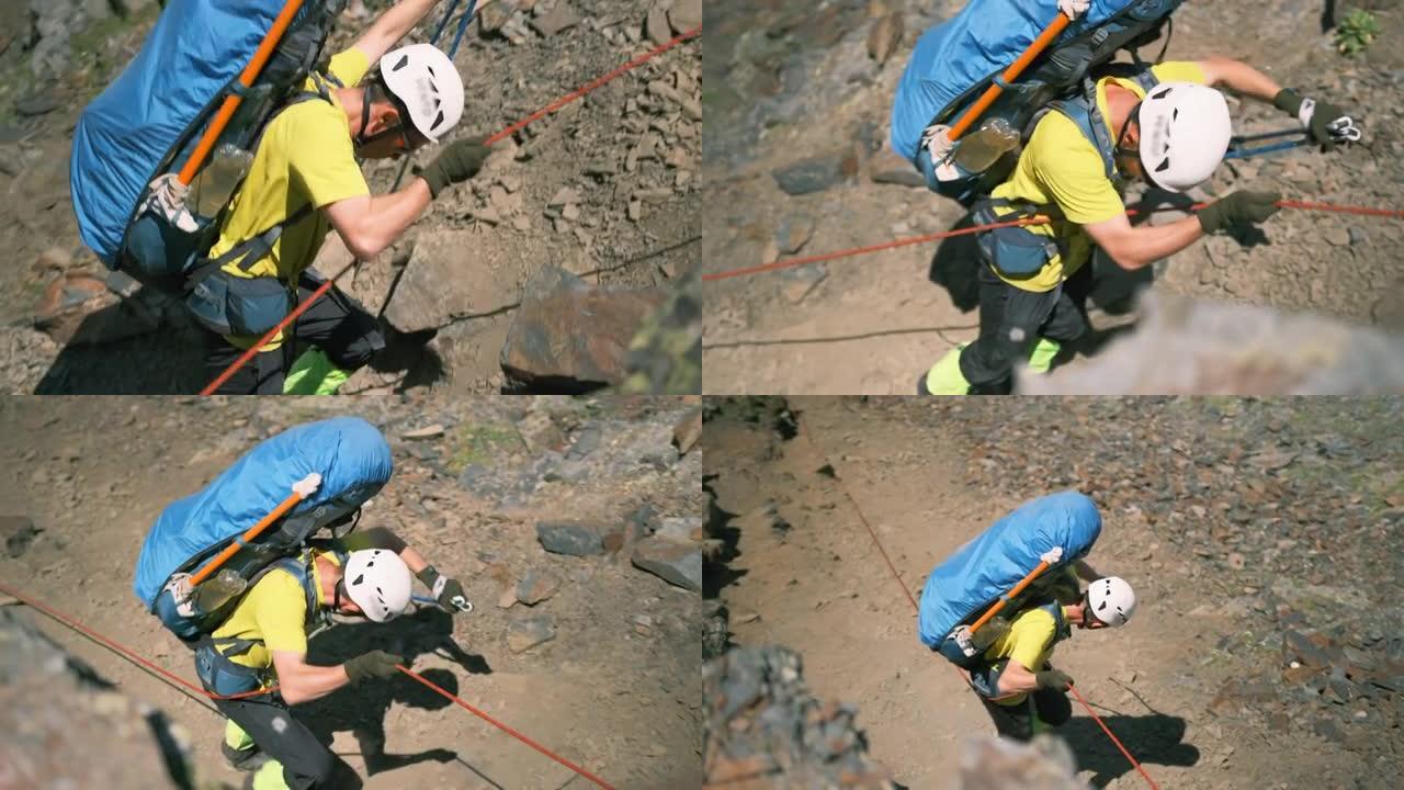 一个背着装备的背包的男人用绳子从悬崖上掉下来