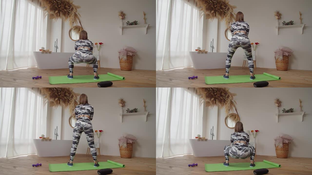 在家庭房间里进行蹲下锻炼的运动健美女性的后视图