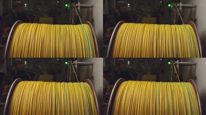 电缆生产中带有黄色电缆的旋转卷轴特写