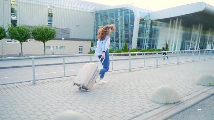 年轻的时尚女孩嬉皮士游客提着行李箱去机场迟到了