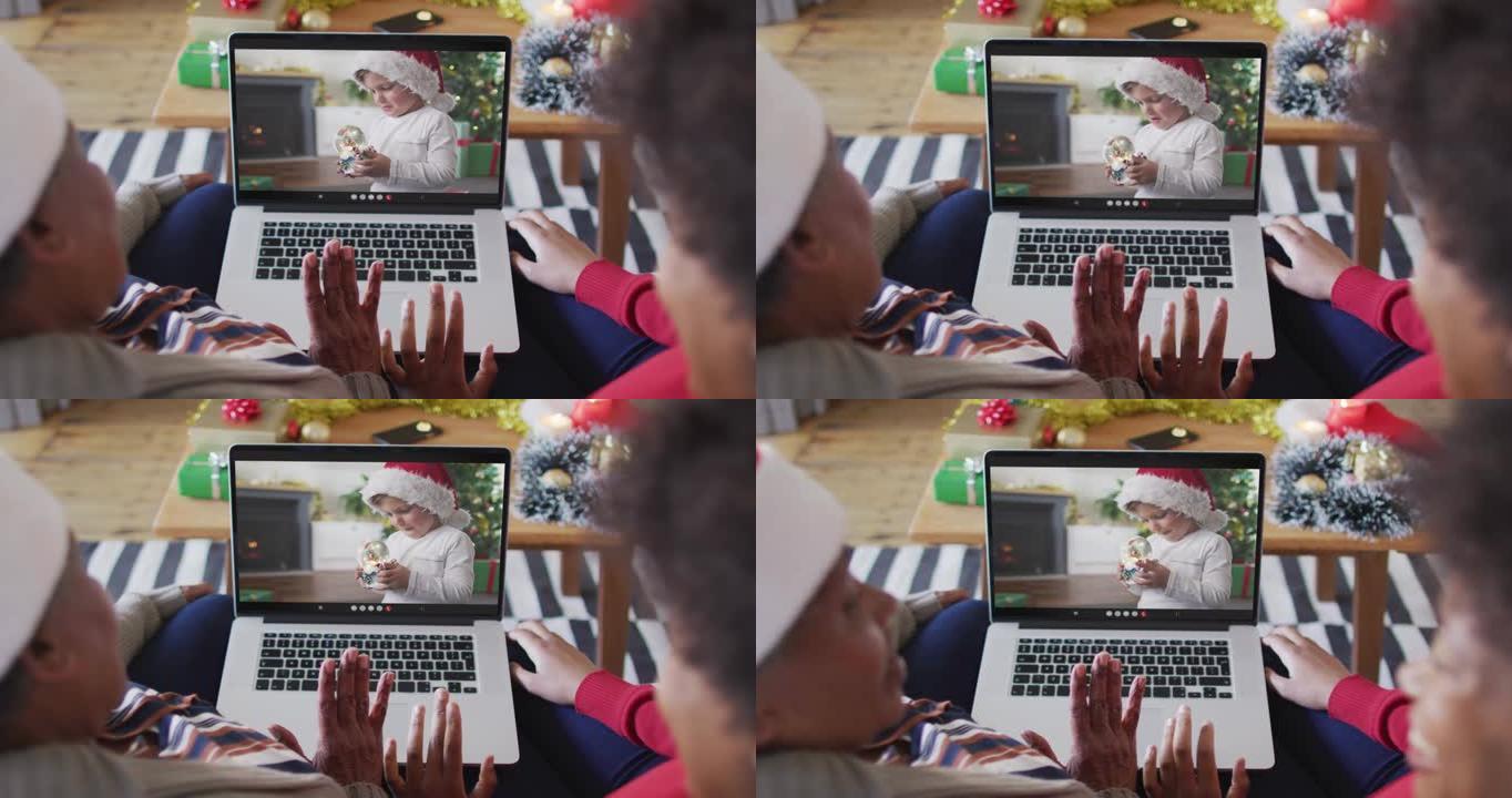 非裔美国母亲和女儿使用笔记本电脑与屏幕上的男孩进行圣诞节视频通话