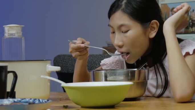 亚洲女孩晚上在家与家人一起吃sha锅或寿喜烧，生活方式理念。