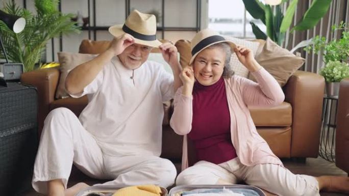 亚洲老年夫妇一起打包布包旅行，幸福亚洲老年退休成熟成年人享受在客厅地板上一起整理布包，为锁定后旅行做
