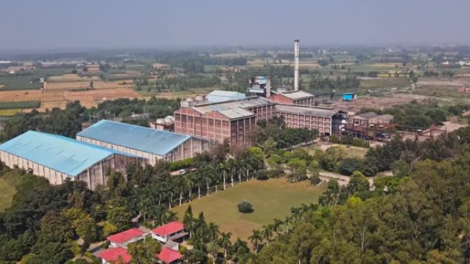 印度糖厂的鸟瞰图被麦田和树木包围。