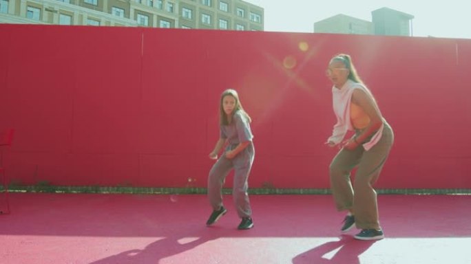 女舞者教练教青少年女童在阳光下跳舞。当代舞蹈学校广告