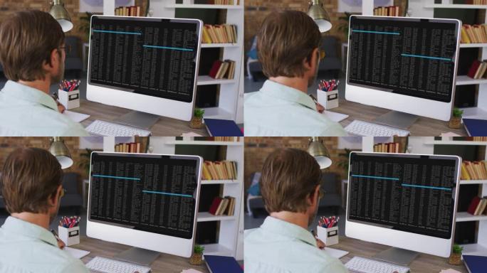 白人男子坐在办公桌前观看计算机屏幕上的编码数据处理
