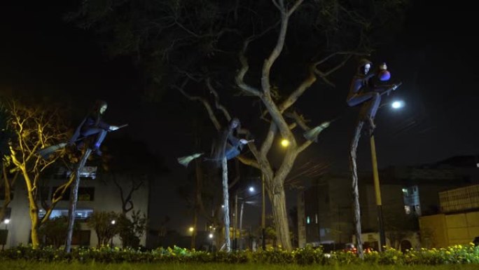 夜间公园稻草扫帚上的三个可怕的女巫雕塑