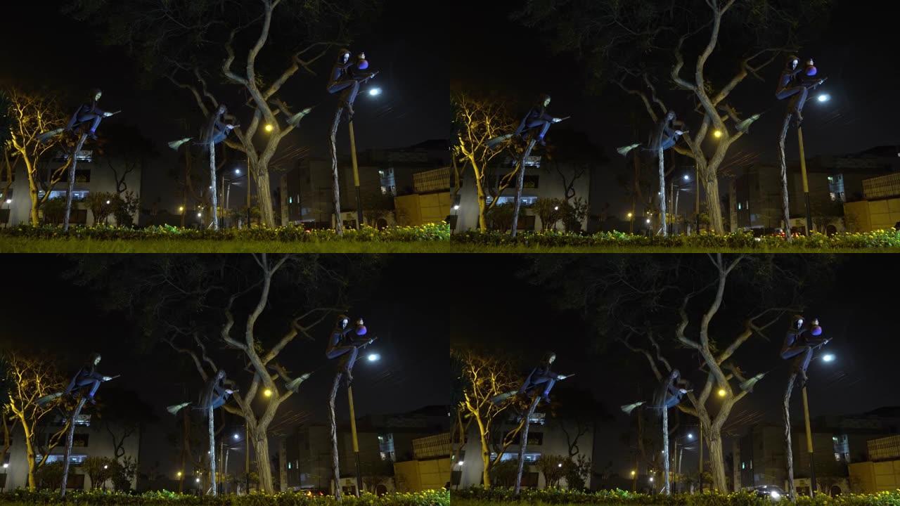 夜间公园稻草扫帚上的三个可怕的女巫雕塑