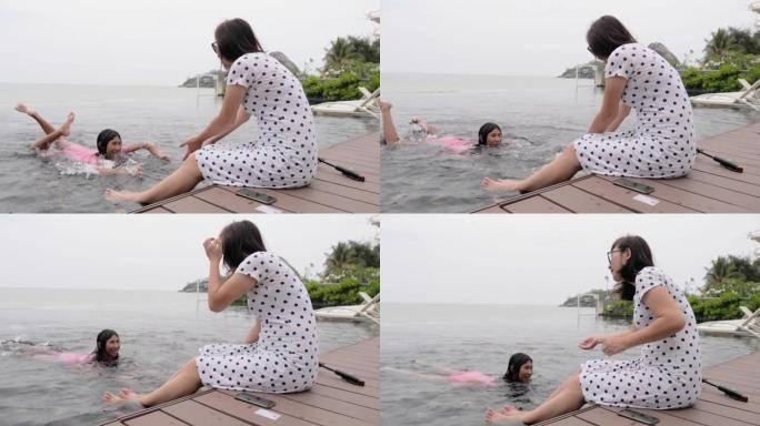 快乐的亚洲成年女性放松，看着女儿在度假期间一起在酒店游泳，生活方式理念。