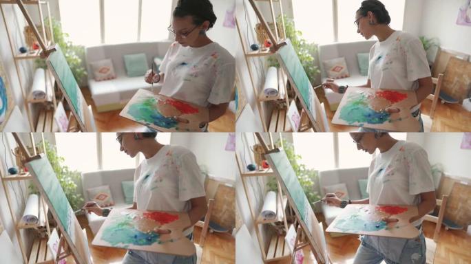 有天赋的女艺术家用丙烯酸涂料在画布上绘画海洋和海滩