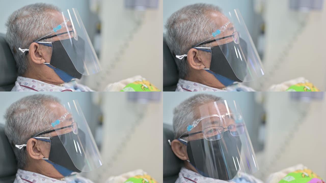 亚洲华人老人坐在椅子上，戴着面罩，正在医院接受透析治疗