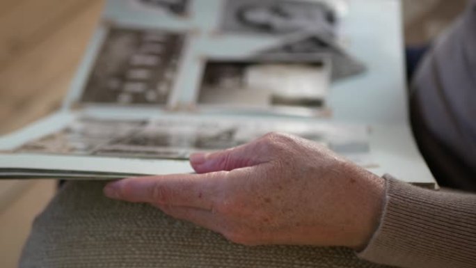 成年妇女在家里看起来像旧相册