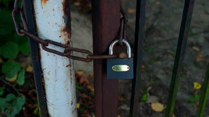 用铁链和简单挂锁固定的封闭式生锈金属门
