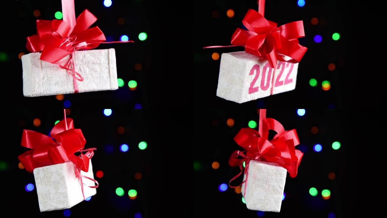 带有文本2022的礼品盒在黑色背景上旋转，新年贺卡，bokeh，选择性聚焦