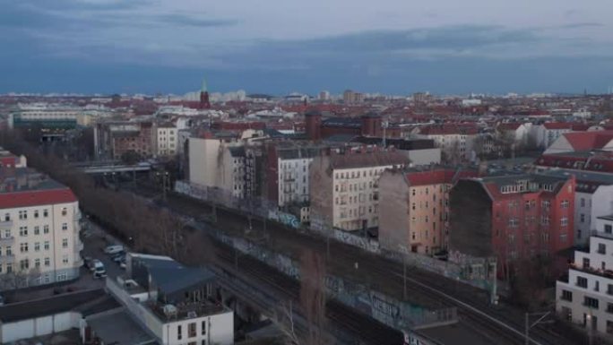 德国柏林清晨停放的传统砖砌住宅和车辆附近空铁路线的空中慢动作视图