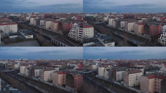 德国柏林清晨停放的传统砖砌住宅和车辆附近空铁路线的空中慢动作视图