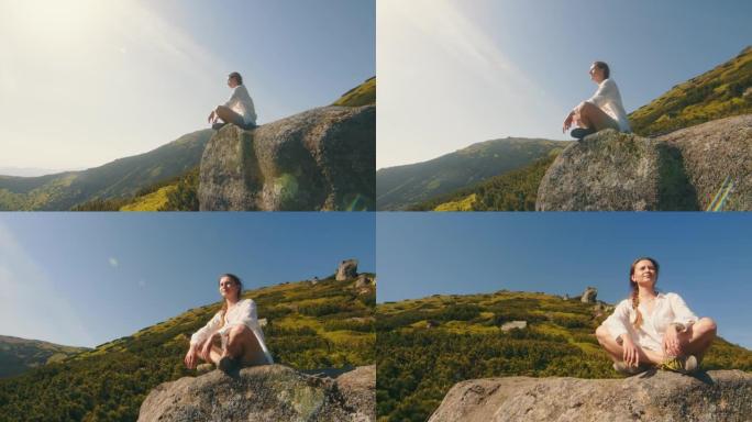女孩运动员坐在山上的一块岩石上，看着大自然的美丽。在山中旅行，感受美丽