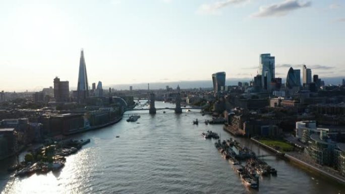 上升泰晤士河和两岸摩天大楼的全景镜头。反射阳光的水面。英国伦敦