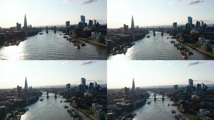 上升泰晤士河和两岸摩天大楼的全景镜头。反射阳光的水面。英国伦敦