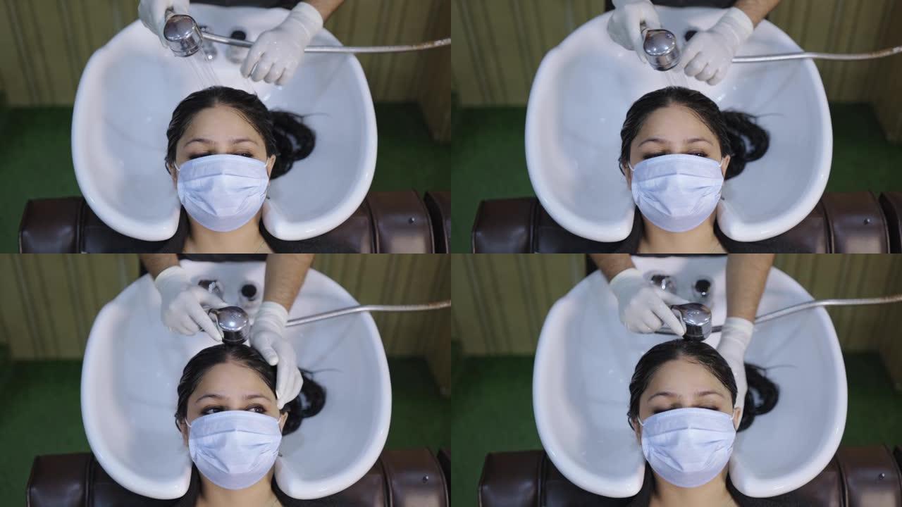 一名戴着防护口罩的女性客户正在洗发和洗发