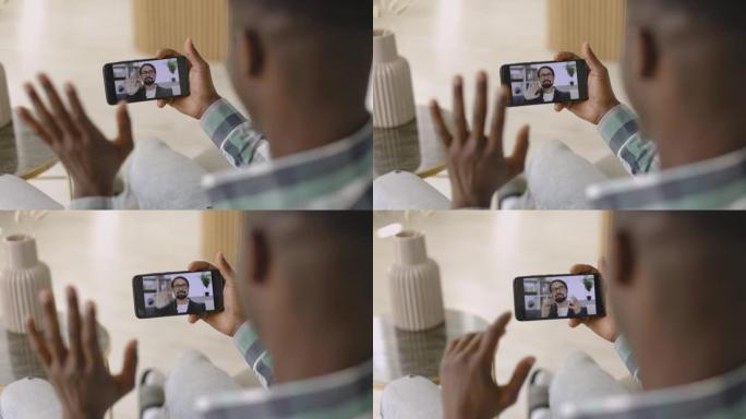 非洲男子在智能手机的网络摄像头中挥手打招呼，同时进行视频通话
