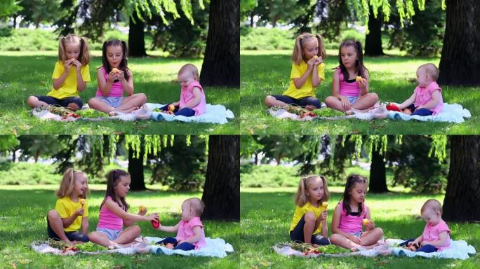三个小女孩正在绿色草坪上吃梨