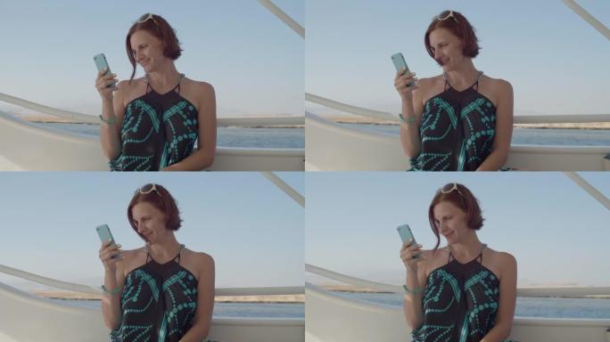 30岁的女人穿着手机在海上航行。船上微笑的女性。
