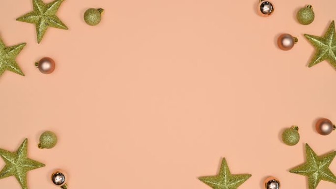 圣诞闪光星星和小装饰品出现，并在柔和的橙色主题上制作框架边框。停止运动