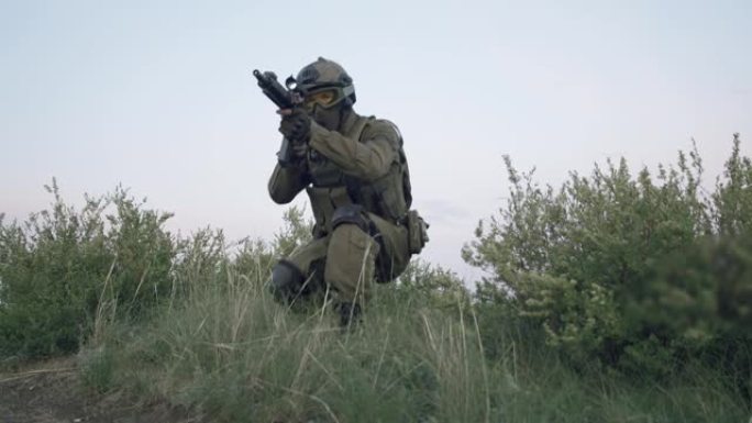 军用装备中的战斗机在草地上爬行，瞄准狙击步枪的目镜。军事概念