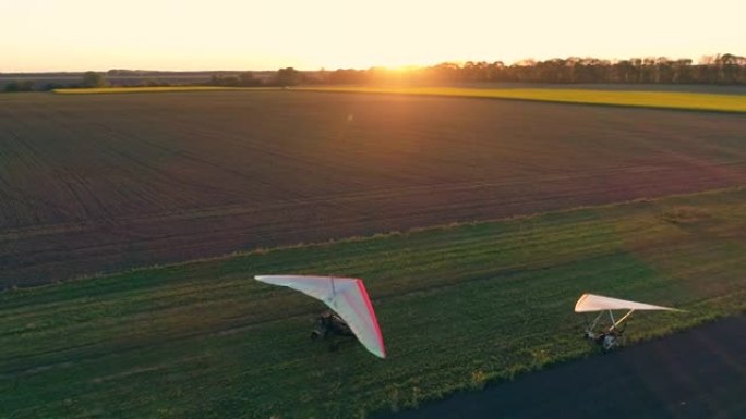 机动悬挂式滑翔机降落在草地跑道上