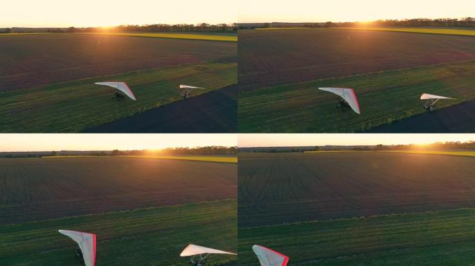 机动悬挂式滑翔机降落在草地跑道上