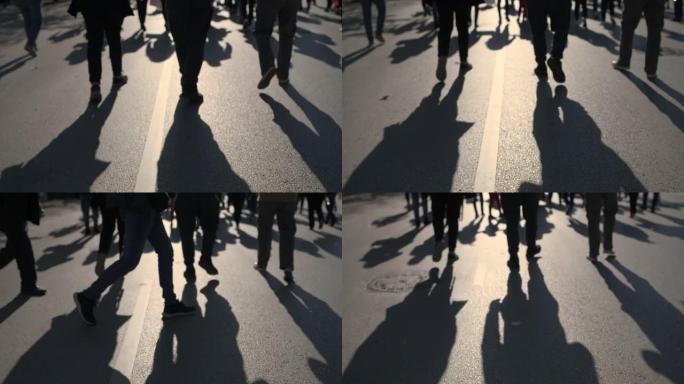 一群人在路上行走的剪影，城市里抗议的活动人士。