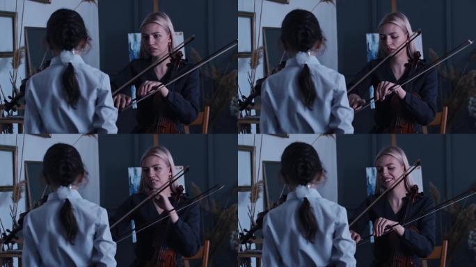 年轻的金发女子教一个小女孩如何在拉小提琴时正确握弓