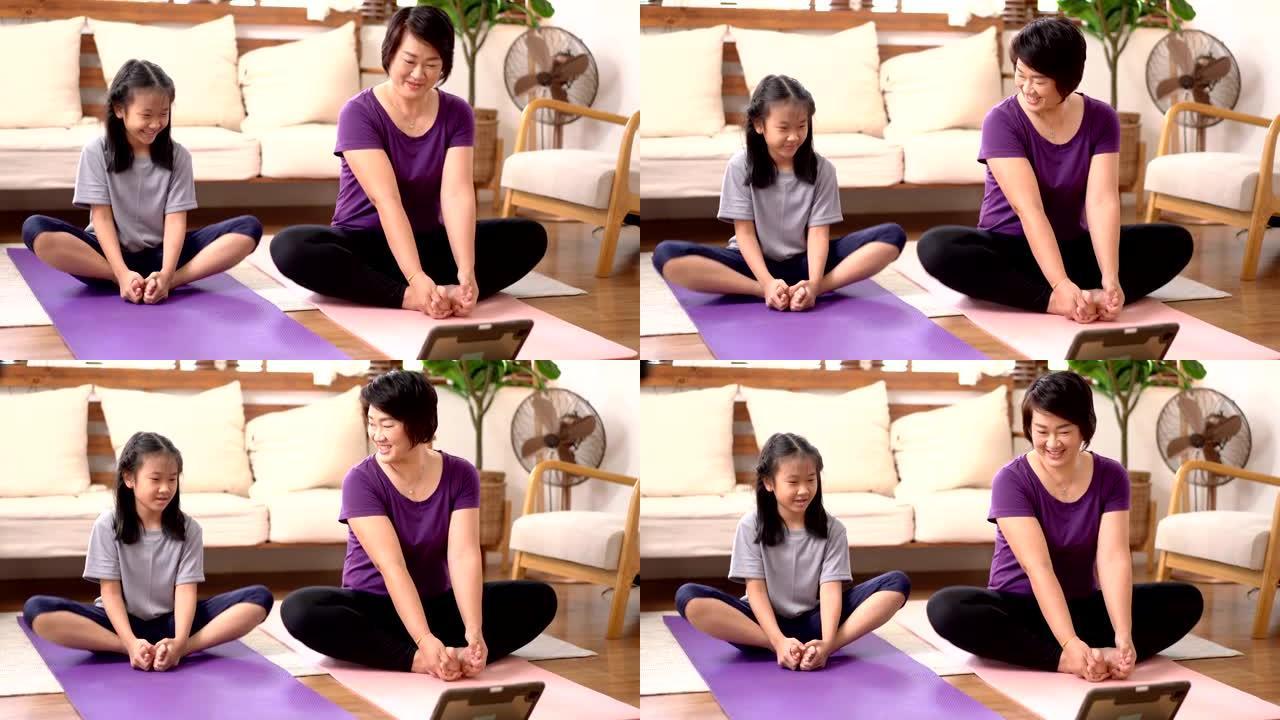 亚洲母女在家做瑜伽带着幸福