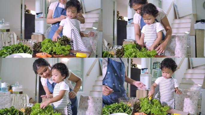 母亲和蹒跚学步的男孩在做蔬菜沙拉。