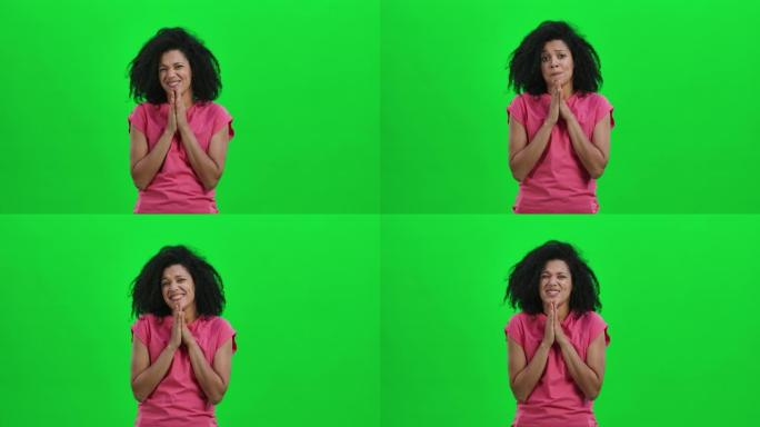 年轻女性非裔美国人保持手掌并索要东西的肖像。卷发的黑人妇女在工作室的绿色屏幕上摆姿势。特写。慢动作就