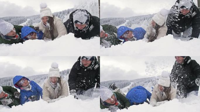 一群朋友兴高采烈地互相撒雪。美好的冬日。在白雪皑皑的森林背景下