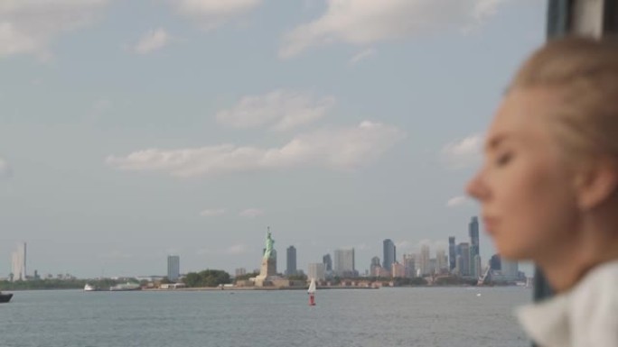 一个年轻女孩从渡轮上欣赏曼哈顿下城的景色
