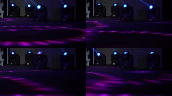 舞台灯光农场的四台彩色投影仪。明亮闪亮的舞台灯闪烁运动娱乐聚光灯投影仪在黑暗中，蓝色柔和的聚光灯在黑