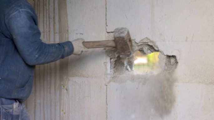 一个人用锤子在墙上打洞的慢动作