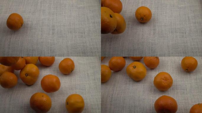 橘子落在白色的粗麻布上，慢动作