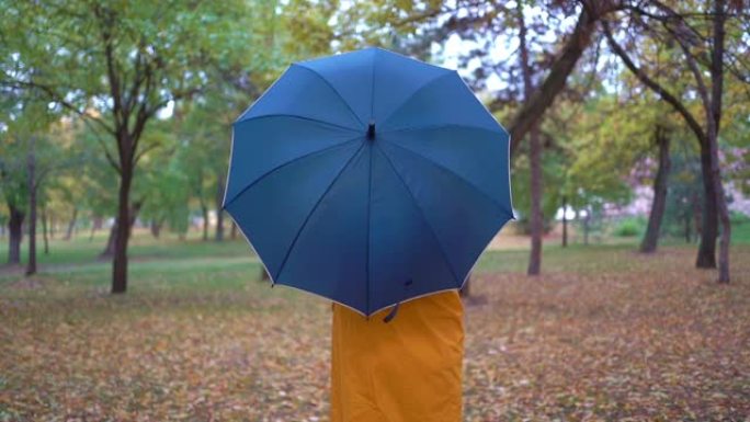 秋季公园旋转雨伞背后的人