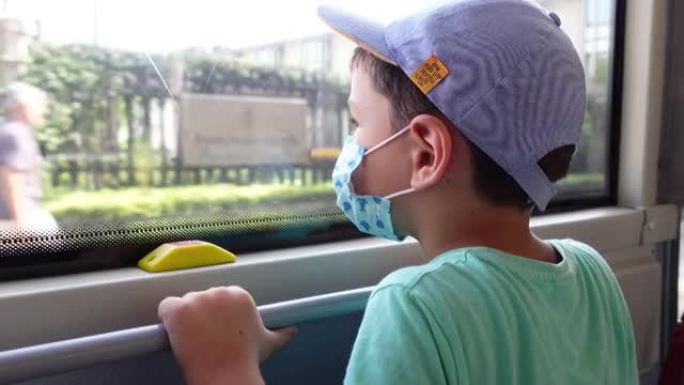小男孩在公共汽车上戴着防护口罩