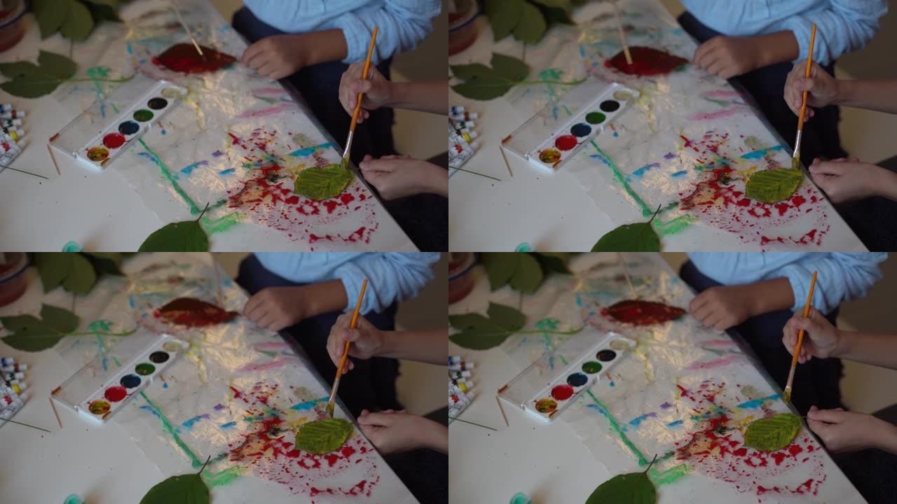孩子们的秋季工艺。用枫叶制成的动物狐狸。儿童艺术和创意。由天然材料制成的手工艺品。女孩用颜料画画。